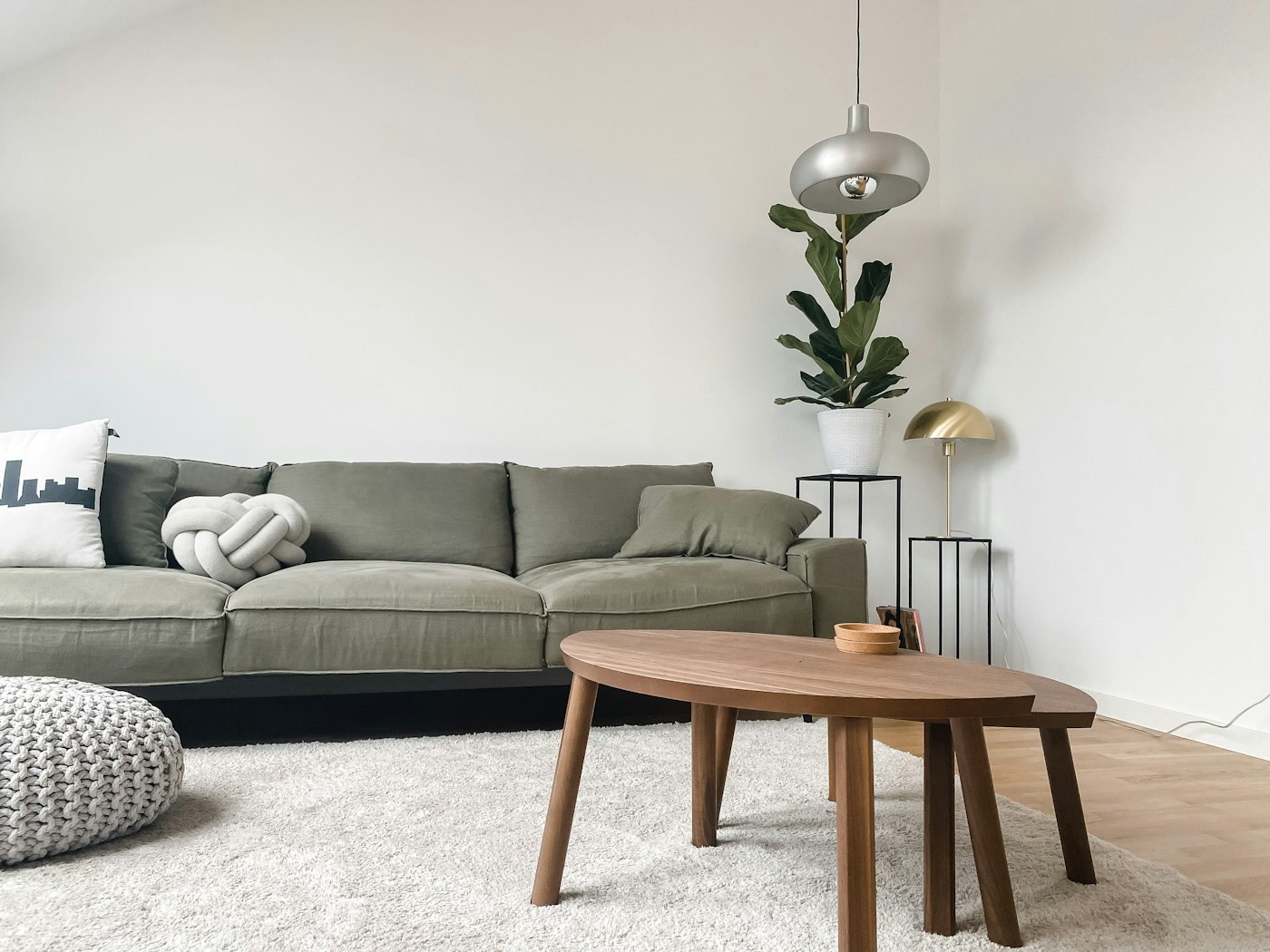 A bright living room with a pale sofa and a large window